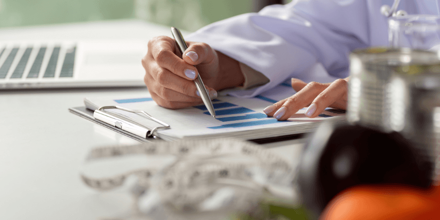 Healthcare for U.S. Expats Cropped photo of a healthcare professional reviewing charts and medical data on a desk — healthcare for U.S. expats and retirees.