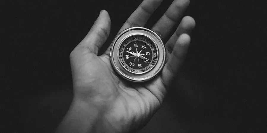 QROPS in 2025 Essential Guidance for UK Expats Blog Image Hand holding a compass in monochrome, symbolizing UK expats navigating QROPS rules in 2025.