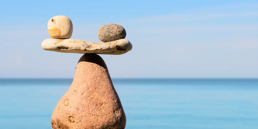 Taxes and Legal Considerations for American Retirees Abroad Stacked balancing rocks by the ocean symbolizing stability and balance for American retirees abroad.